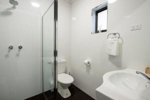 a white bathroom with a toilet and a sink at City Centre Motel Hotel in Port Pirie +19 photos