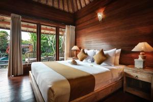 a bedroom with a large bed with wooden walls at Yana Villas Kemenuh by GenuineHost in Ubud