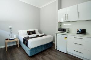 a small bedroom with a bed and a microwave at City Centre Motel Hotel in Port Pirie