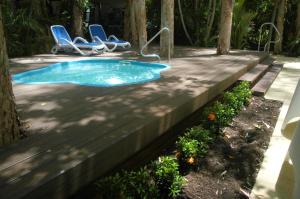una piccola piscina su una terrazza in legno con due sedie di The Reef Retreat Palm Cove a Palm Cove