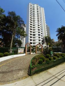 duży biały budynek apartamentowy z płotem przed nim w obiekcie Royal Ibirapuera Park - Flat w São Paulo