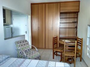 a bedroom with a table and a chair and a dining room at Edifício Lord - APTO in São Vicente