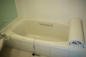 una vasca da bagno bianca seduta in una stanza di Villa Sapporo Honobono a Sapporo