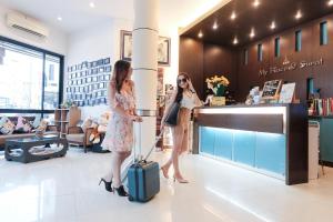 two girls are standing in a store with their luggage at Myplace@Surat Hotel in Suratthani