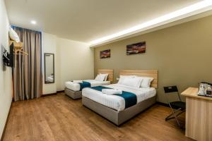 Postel nebo postele na pokoji v ubytování 1 Orange Hotel Sungai Buloh