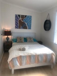 a bedroom with a bed with a painting on the wall at Inglewood Comfort in Perth