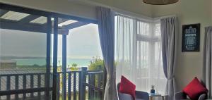 a room with a large window with a view of the ocean at Oamaru Harbour Nest in Oamaru