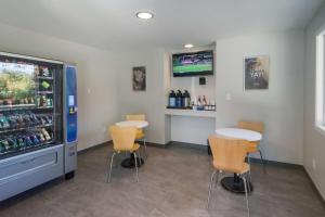 a room with two tables and a refrigerator with drinks at Motel 6-Saanichton, BC - Victoria Airport in Saanichton