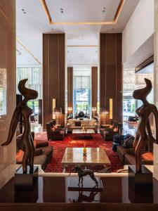 a living room with a couch and a table at Eastin Grand Hotel Sathorn in Bangkok