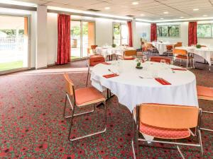 a conference room with white tables and chairs at ibis Beziers Est Mediterranee A9/A75 in Béziers