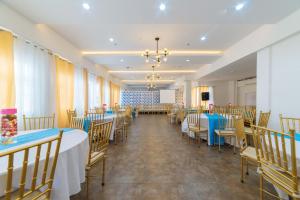 une salle de banquet avec des tables et des chaises ainsi qu'un podium dans l'établissement RedDoorz Plus at Hotel Metro Kalibo, à Kalibo