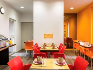 a dining room with red chairs and a table at Aparthotel Adagio Access Paris Philippe Auguste in Paris
