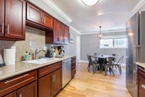 a kitchen with wooden cabinets and a table with chairs at @ Marbella Lane Seaside Retreat, Walk to the Beach in Half Moon Bay