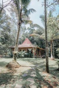 a house with palm trees in front of it at Saridevi Ecolodge in Jatiluwih