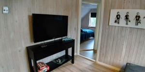 sala de estar con TV de pantalla plana en la pared en Lenes logi en Herning