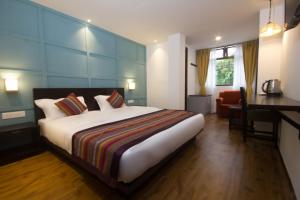 Habitación de hotel con cama grande y escritorio. en Bumblebee Bed & Breakfast, en Gangtok
