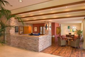 a lobby with a stone bar with chairs and a table at Alva Hotel Apartments in Protaras