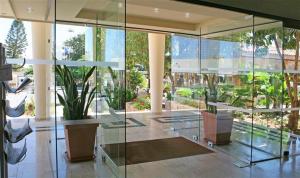 a lobby with glass walls and a potted plant at Alva Hotel Apartments in Protaras