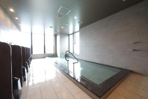 Habitación con baño grande con piscina. en Miyako Hotel Hakata en Fukuoka