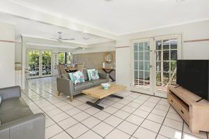 a living room with a couch and a tv at Coral Beach Noosa Resort in Noosaville