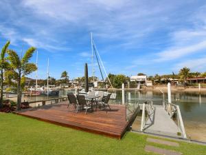 a wooden deck with chairs and a table on a boat at WATERFRONT HOME BORDERING MOOLOOLABA in Buddina