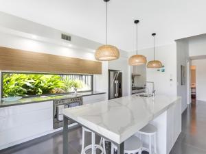 a kitchen with a white counter top and a large island at WATERFRONT HOME BORDERING MOOLOOLABA in Buddina