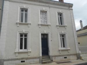 - un bâtiment blanc avec une porte et des fenêtres bleues dans l'établissement MAISON EN VILLE, à Airvault
