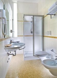 ein Badezimmer mit Dusche, Toilette und Waschbecken in der Unterkunft Acapulco Hotel in Cattolica