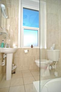 a bathroom with a toilet and a sink and a window at The Aqua in Portland