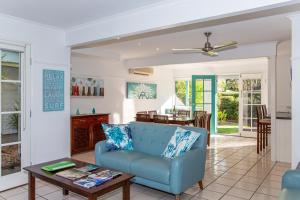 een woonkamer met een blauwe bank en een tafel bij Coral Beach Noosa Resort in Noosaville