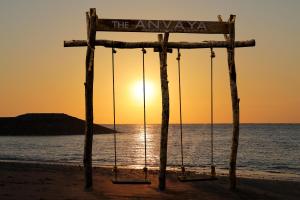 クタにあるザ アンヴァヤ ビーチ リゾート バリの夕日を背景にビーチでのブランコ