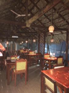 comedor con mesas y sillas de madera en Anitha's Garden Stay, en Kovalam