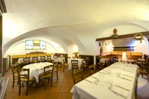 un restaurante con mesas y sillas con manteles blancos en Albergo Cristofoli, en Treppo Carnico