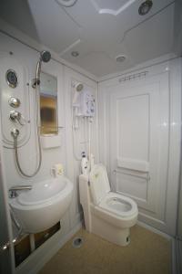 a white bathroom with a toilet and a sink at gayang friendly water house homestay in Kota Kinabalu