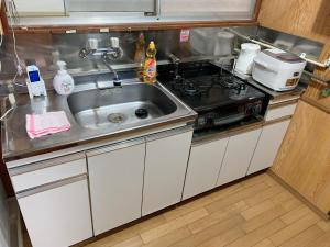 cocina con fregadero y fogones en Vivian house en Tokio