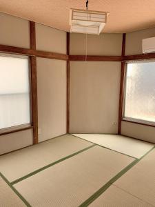 Habitación vacía con 2 ventanas y techo en Vivian house en Tokio