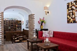 a living room with a red couch and tables at Capri Wine Hotel in Capri