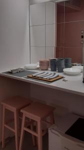 a kitchen with two stools and a counter with dishes at Lovely Madly Apartment in Krakow