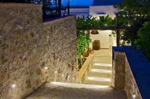 a stairway with lights on a stone wall at night at Capri Wine Hotel in Capri