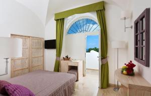 a bedroom with a bed and a door with a window at Capri Wine Hotel in Capri