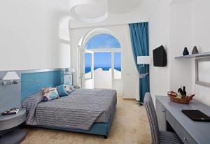 a bedroom with a bed and a desk with a computer at Capri Wine Hotel in Capri
