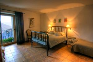 een slaapkamer met een bed en een groot raam bij Casa Massa in Baro