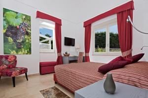 a bedroom with a red bed and a chair at Capri Wine Hotel in Capri