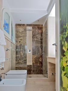 a bathroom with a shower with a toilet and a sink at Capri Wine Hotel in Capri