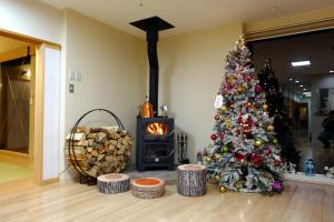 a christmas tree in a living room with a fireplace at Villa Sapporo Honobono in Sapporo