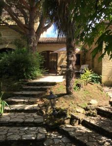 un jardín con una palmera y un semáforo en La Closerie de Baneuil en Baneuil