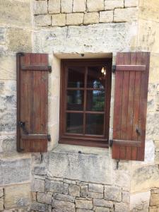 Baneuil的住宿－La Closerie de Baneuil，两扇窗户,位于石头建筑的一侧