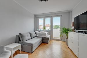 ein Wohnzimmer mit einem Sofa und einem TV in der Unterkunft Apartament z widokiem na morze in Sopot