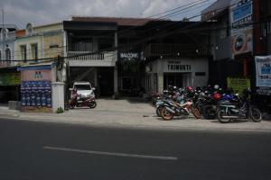 a group of motorcycles parked on the side of a street at RedDoorz Hostel @ Borobudur Street in Blimbing