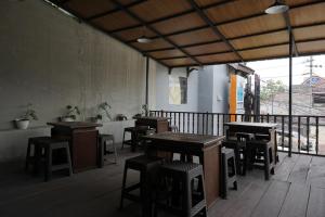 a restaurant with tables and chairs in a room at RedDoorz Hostel @ Borobudur Street in Blimbing